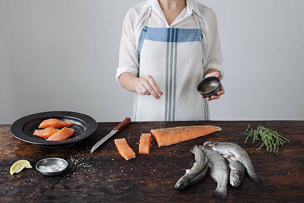 Chef cuisinier qui prépare une recette à base de saumon